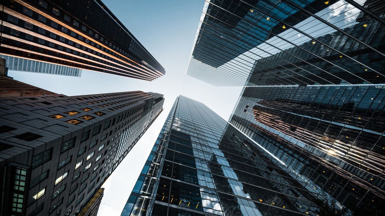 Business and Finance, Looking Up at High Rise Office Buildings in the Financial District of a Modern Metropolis Business and finance concept, looking up at futuristic skyscrapers in the financial district of a modern metropolis.